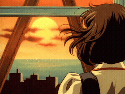 A Woman Is Looking Out A Window At The Sun Setting Over The Ocean GIF