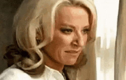 A Woman Is Looking Out Of A Window On An Airplane . GIF