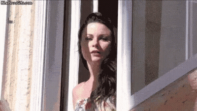 A Woman Is Looking Out Of A Window With Hilariousgifs.com Written On The Bottom GIF
