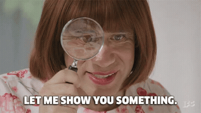 A Woman Is Looking Through A Magnifying Glass And Says Let Me Show You Something GIF
