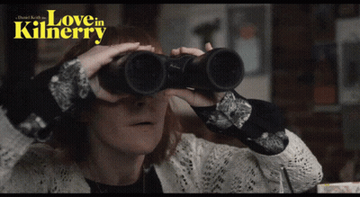 A Woman Is Looking Through Binoculars With The Words Love In Kilnerry Written Above Her GIF