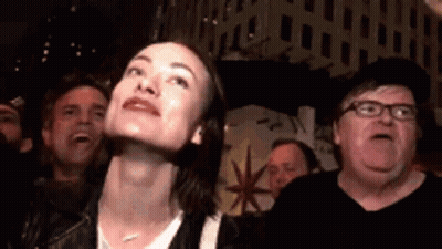 A Woman Is Looking Up At Something While A Man Looks Down At Her . GIF
