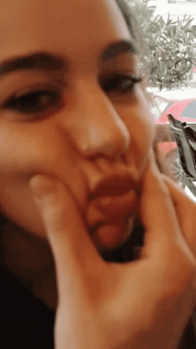 A Woman Is Making A Face With Her Hands GIF