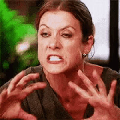 A Woman Is Making A Funny Face And Making A Funny Face With Her Hands . GIF