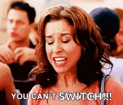 A Woman Is Making A Funny Face And Saying `` You Can 'T Switch ! '' In Front Of A Crowd Of People . GIF