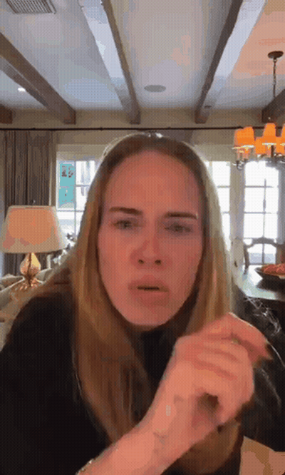 A Woman Is Making A Funny Face In A Living Room With A Lamp . GIF