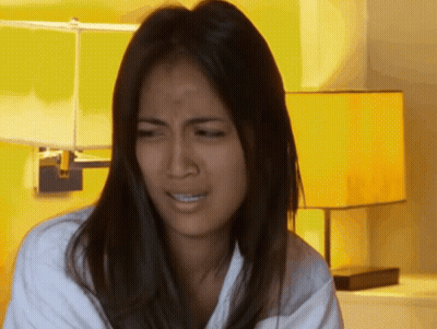 A Woman Is Making A Funny Face In Front Of A Lamp GIF