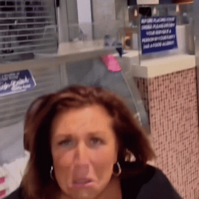 A Woman Is Making A Funny Face In Front Of A Sign That Says ' Change Flavors ' GIF