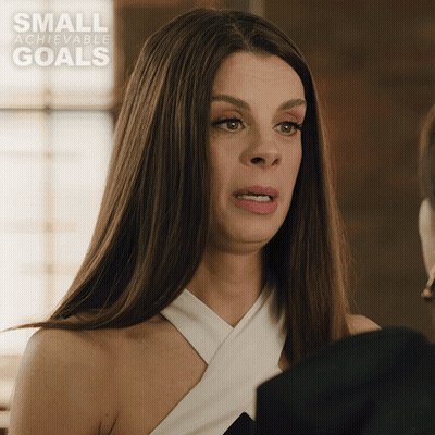 A Woman Is Making A Funny Face In Front Of A Small Achievable Goals Ad GIF