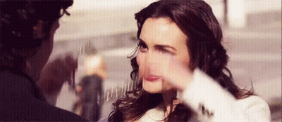 A Woman Is Making A Funny Face While A Man Holds Her Face . GIF
