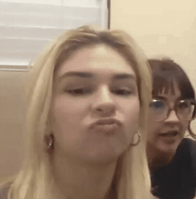 A Woman Is Making A Funny Face While Another Woman Looks On . GIF
