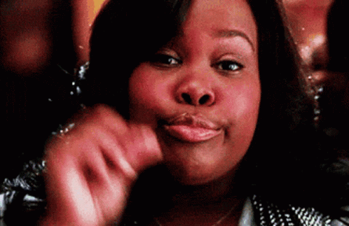 A Woman Is Making A Funny Face While Holding Her Hand To Her Face . GIF