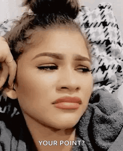A Woman Is Making A Funny Face While Laying On A Bed And Covering Her Ears . GIF