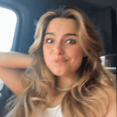 A Woman Is Making A Funny Face While Sitting In A Car . GIF