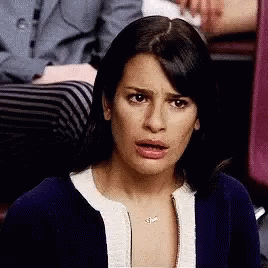 A Woman Is Making A Funny Face While Sitting In A Chair . GIF