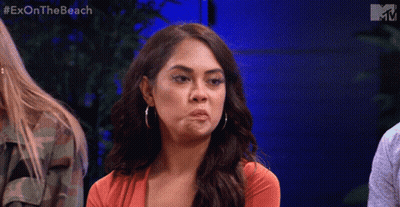 A Woman Is Making A Funny Face While Sitting In Front Of A Blue Wall With The Words Exon The Beach On It GIF