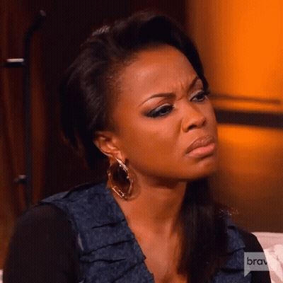 A Woman Is Making A Funny Face While Sitting On A Couch . GIF