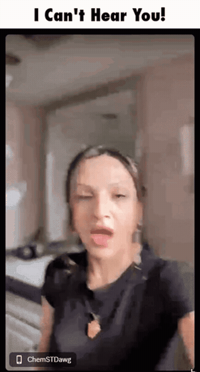 A Woman Is Making A Funny Face While Standing In A Room With Her Eyes Closed . GIF