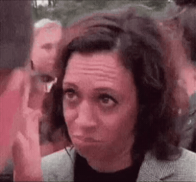 A Woman Is Making A Funny Face While Standing In Front Of A Crowd . GIF