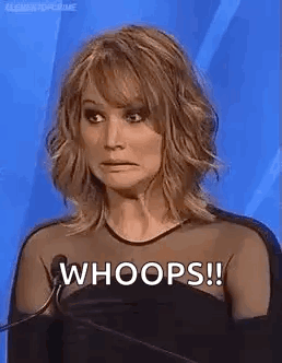 A Woman Is Making A Funny Face While Standing In Front Of A Microphone And Saying Whoops . GIF