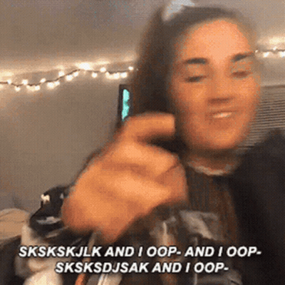 A Woman Is Making A Funny Face While Talking On A Cell Phone In A Room . GIF