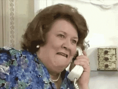A Woman Is Making A Funny Face While Talking On A Phone . GIF
