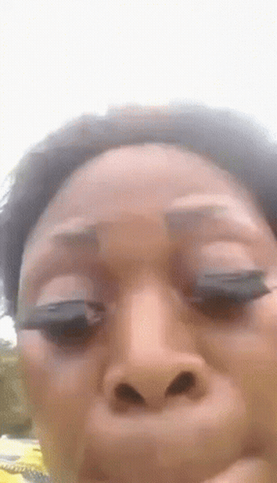 A Woman Is Making A Funny Face With Her Eyes Closed . GIF