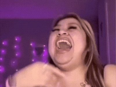 A Woman Is Making A Funny Face With Her Mouth Open And Purple Lights In The Background . GIF