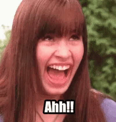 A Woman Is Making A Funny Face With Her Mouth Open And The Words `` Ahh '' Written On Her Face . GIF