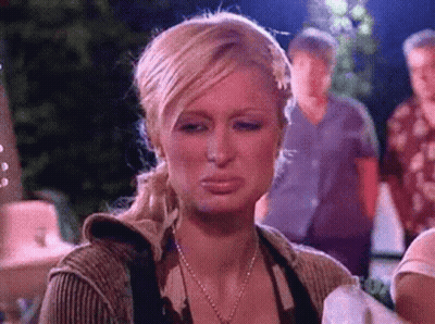 A Woman Is Making A Funny Face With Her Mouth Open While Standing In Front Of A Group Of People . GIF