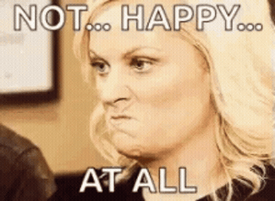 A Woman Is Making A Funny Face With The Words `` Not Happy At All '' Written On Her Face . GIF