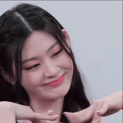 A Woman Is Making A Heart Shape With Her Hands And Smiling . GIF