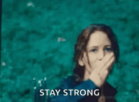 A Woman Is Making A Peace Sign With Her Hand And The Words `` Stay Strong '' Behind Her . GIF