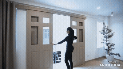 A Woman Is Opening A Sliding Glass Door Made By Animatica GIF