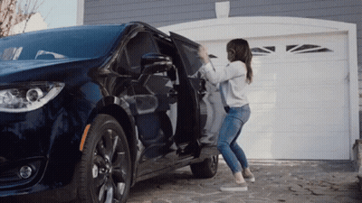 A Woman Is Opening The Door Of A Minivan GIF