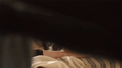 A Woman Is Peeking Out From Behind A Man 'S Shoulder . GIF