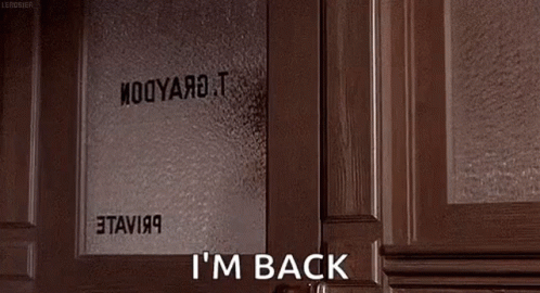 A Woman Is Peeking Out Of A Door And Saying `` I 'M Back '' While Holding A Book . GIF