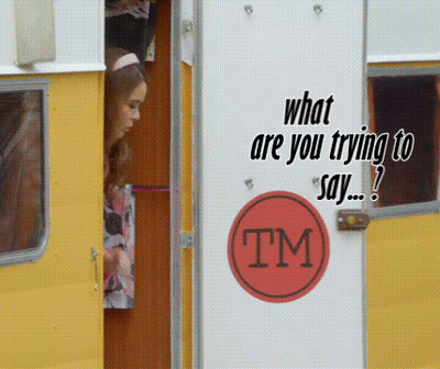 A Woman Is Peeking Out Of A Yellow Trailer With A Tm Sticker On The Door GIF