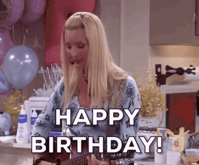 A Woman Is Playing A Guitar In A Kitchen And Says Happy Birthday . GIF