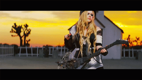 A Woman Is Playing A Guitar In Front Of A White House GIF