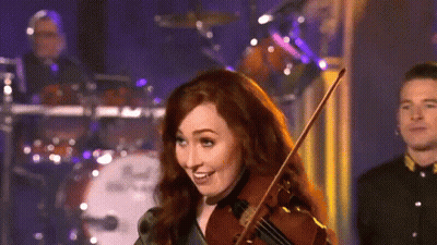 A Woman Is Playing A Violin In Front Of A Drum Set That Says Dw GIF