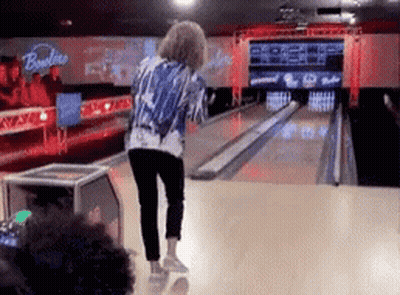 A Woman Is Playing Bowling In A Bowling Alley With A Sign That Says Bowlline GIF