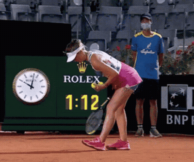 A Woman Is Playing Tennis In Front Of A Rolex Clock GIF