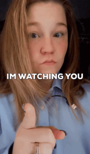 A Woman Is Pointing At The Camera With The Words Im Watching You Above Her GIF