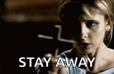 A Woman Is Pointing At The Camera With The Words `` Stay Away '' Written Below Her . GIF