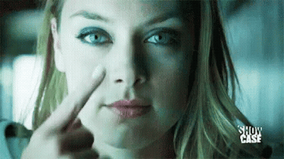 A Woman Is Pointing Her Finger At Her Nose . GIF