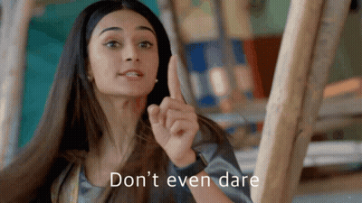 A Woman Is Pointing Up With The Words " Don 'T Even Dare " Written Below Her GIF