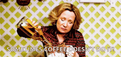 A Woman Is Pouring A Bottle Of Alcohol Into A Glass . GIF
