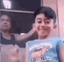 A Woman Is Putting A Hand On A Young Boy 'S Ear . GIF