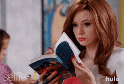 A Woman Is Reading A Book Titled Tales From A Witch GIF